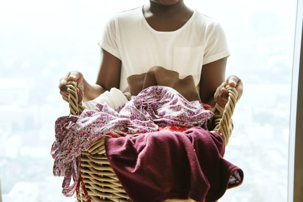 child holding laundry basket helping with chores