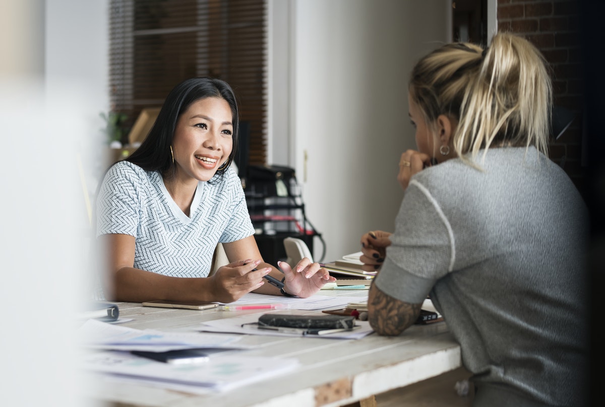Four Mistakes Moms Make at Work woman talking to her boss