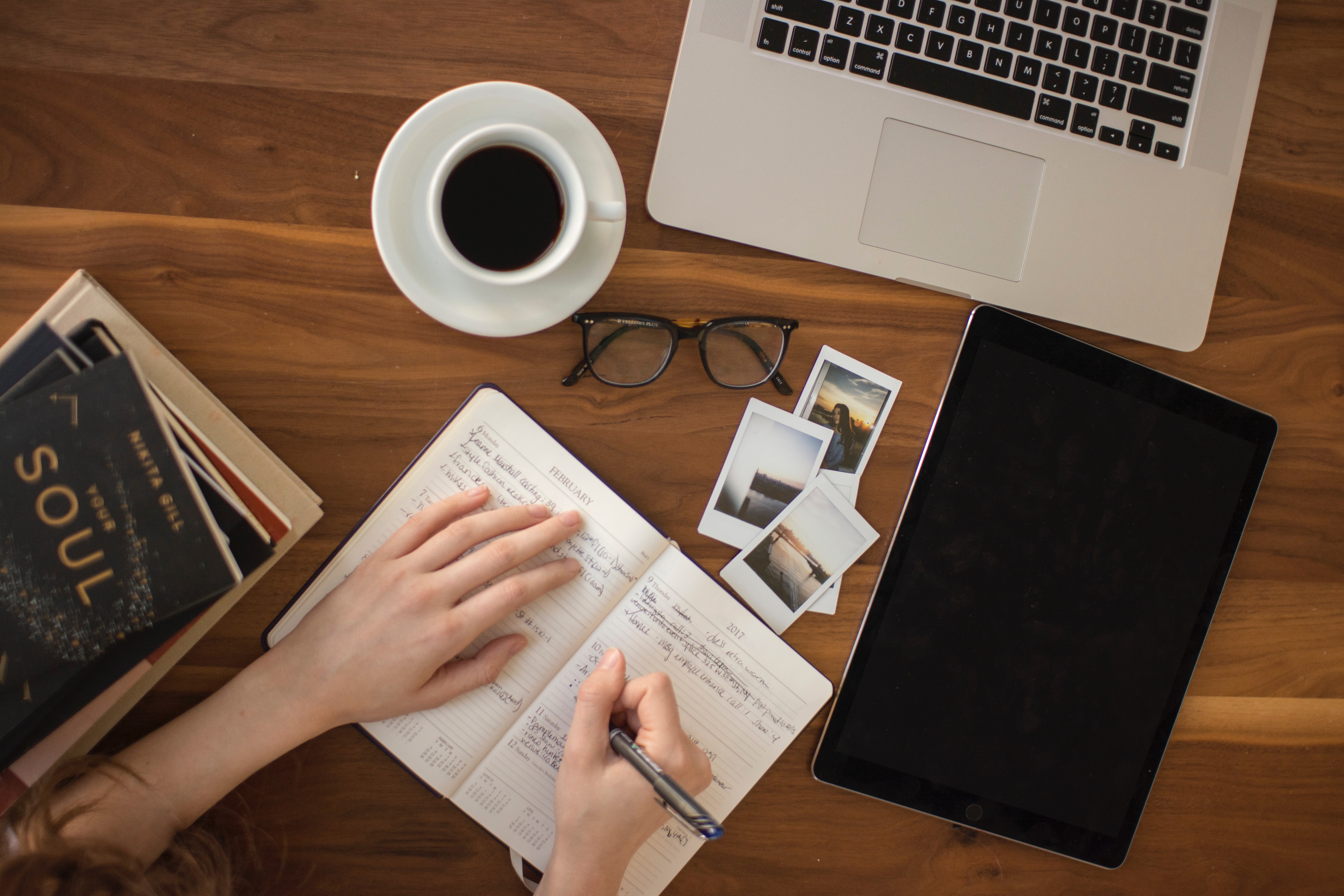 woman writing in journal with computer